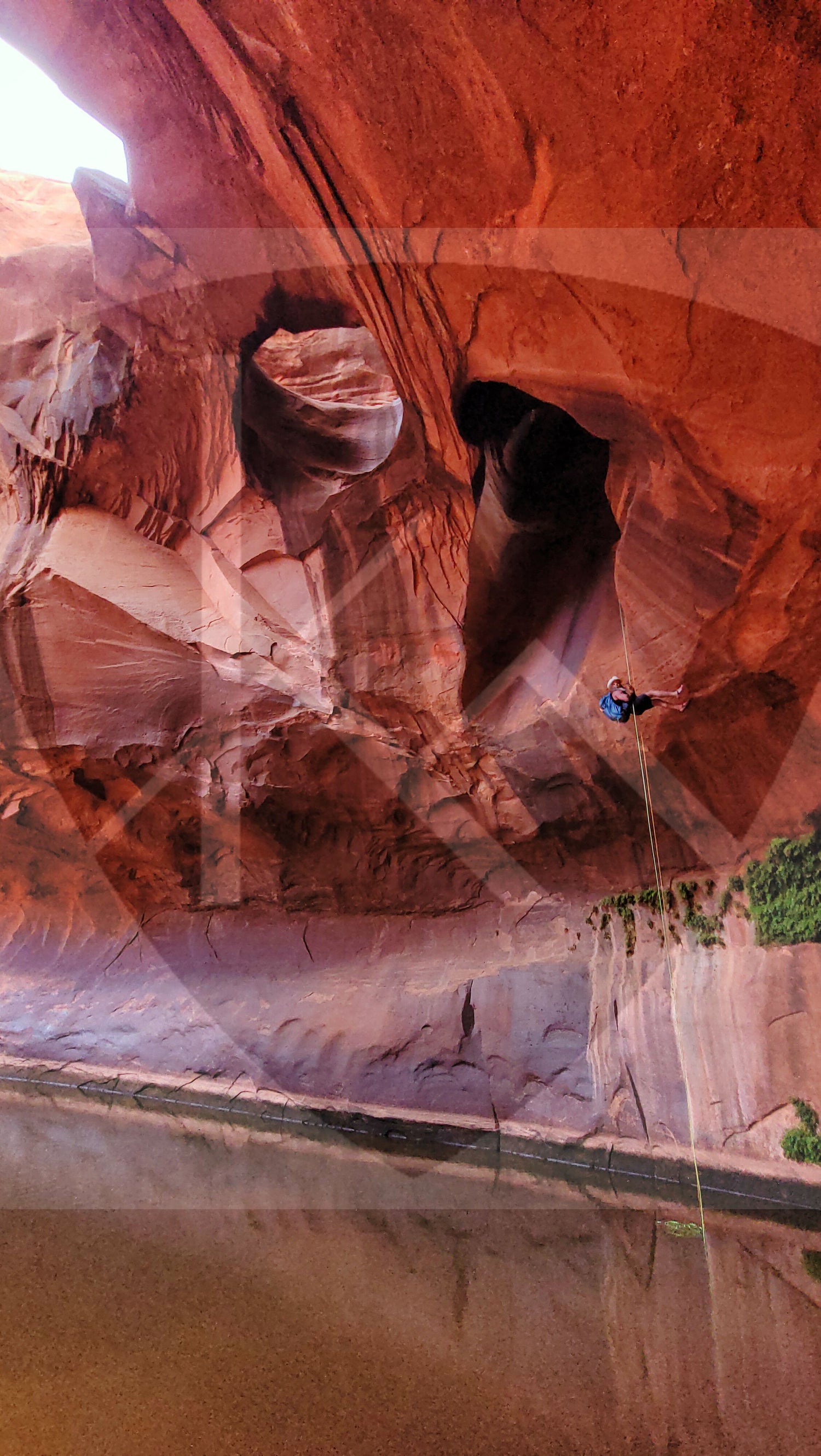 Bearded guy hanging from rappel rope in Golden Cathedral, Utah
