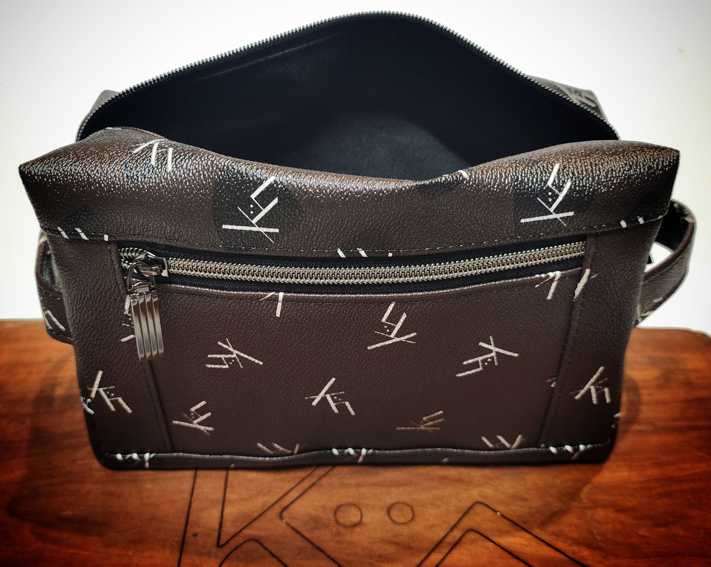 Toiletry bag dopp kit from kühn products dark brown with white logo top view.